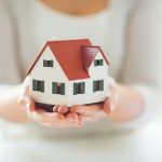 hands with miniature house